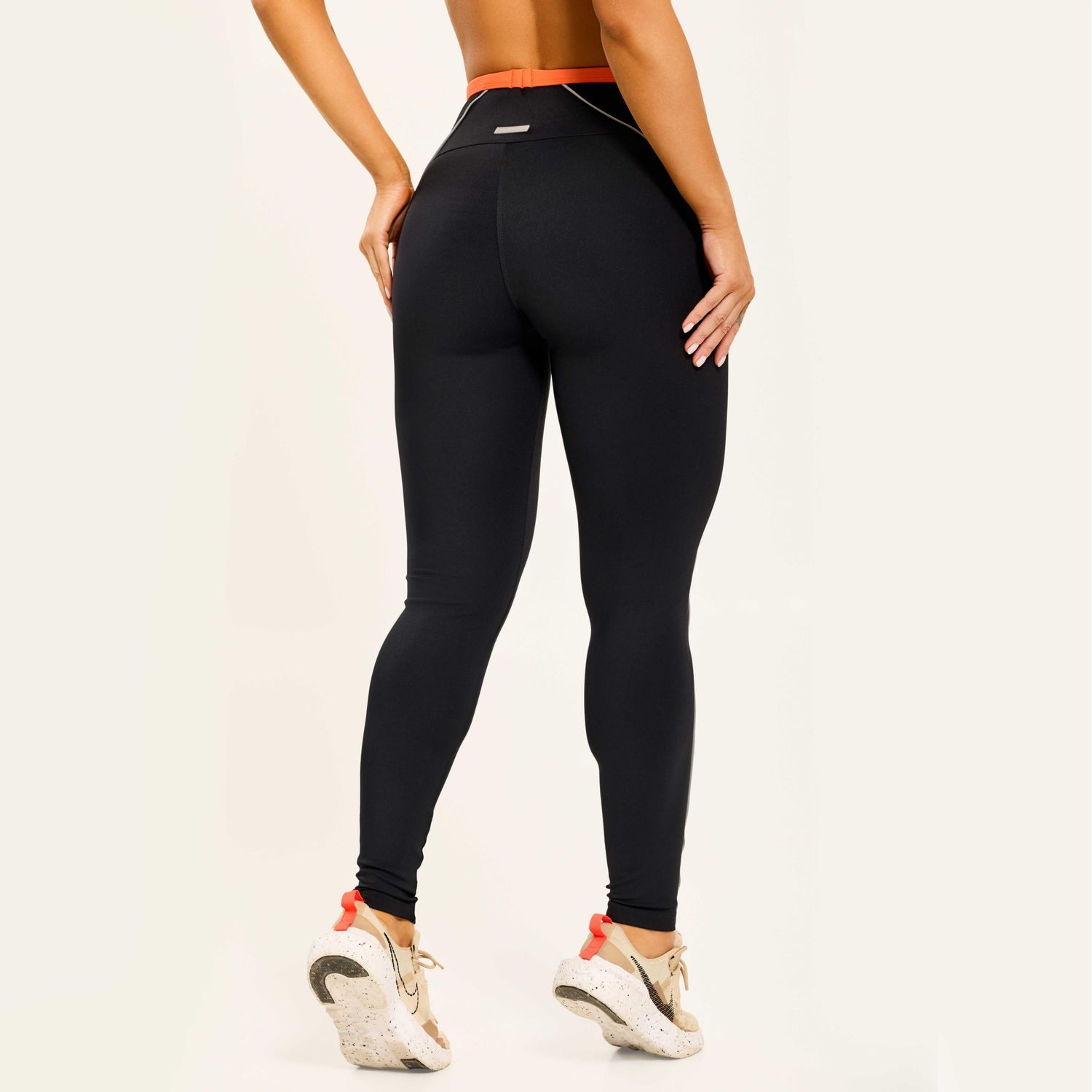 vista-traseira-de-legging-preta-com-cos-laranja-e-detalhe-contrastante-que-valoriza-o-contorno-do-corpo
