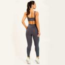 Vista-traseira-de-modelo-com-legging-cinza-e-top-fitness-realce-do-cos-em-formato-V-e-recorte-anatomico