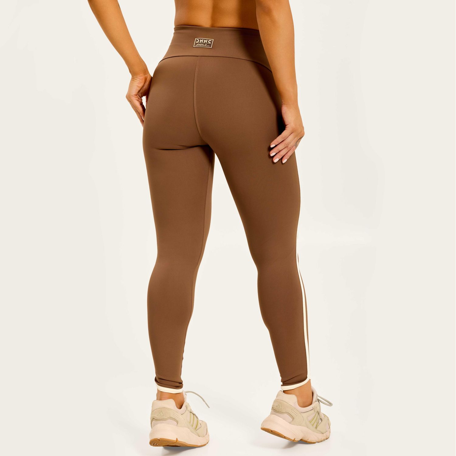 Vista-traseira-da-legging-marrom-de-poliamida-com-cos-alto-e-recorte-bege-realce-natural-do-corpo
