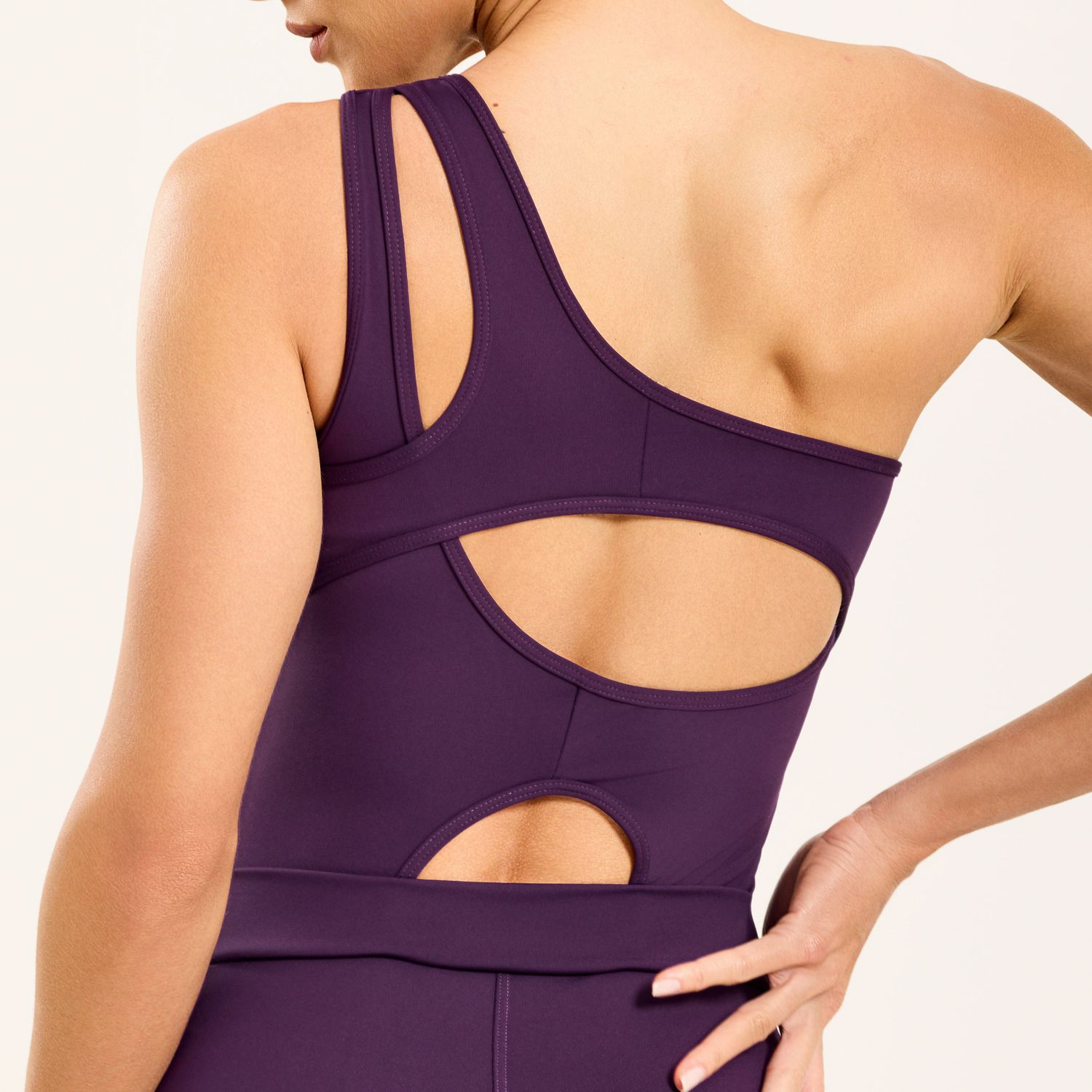 Detalhe-das-costas-do-macaquinho-fitness-roxo-com-recortes-anatomicos-e-alca-dupla.