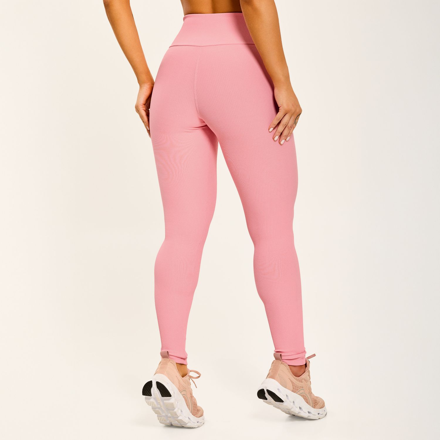 Vista-traseira-de-conjunto-fitness-rosa-top-com-abertura-nas-costas-e-legging-canelada-de-cos-alto