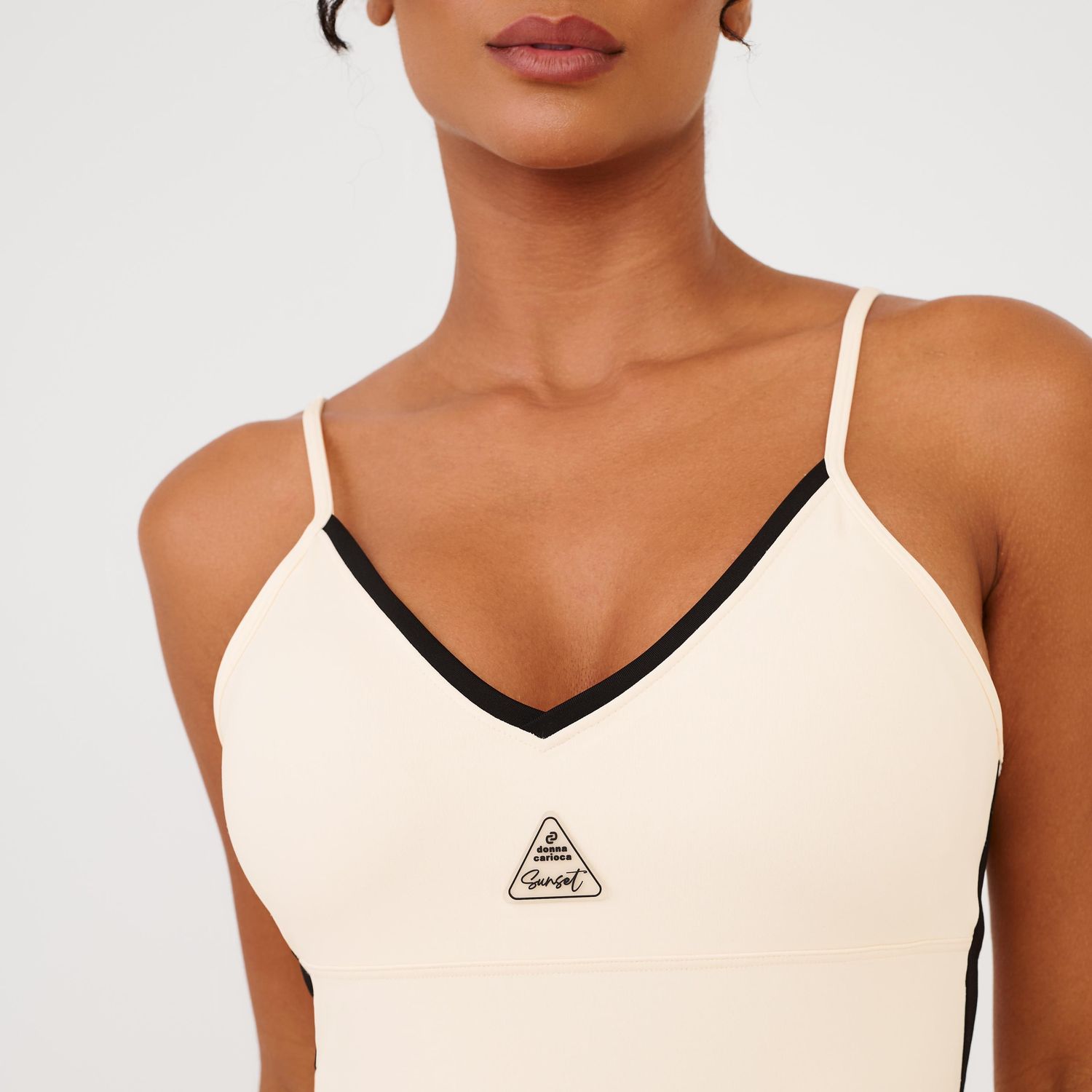 Detalhe-do-busto-do-macaquinho-fitness-bege-com-logo-frontal-e-acabamento-preto.