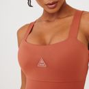 Detalhe-do-busto-do-macaquinho-fitness-terracota-com-logo-frontal-e-tecido-liso.