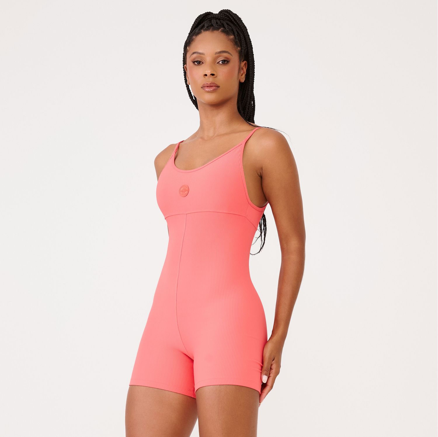Macaquinho-fitness-coral-canelado-de-alcas-finas-vista-em-angulo-com-decote-e-logo-em-destaque.